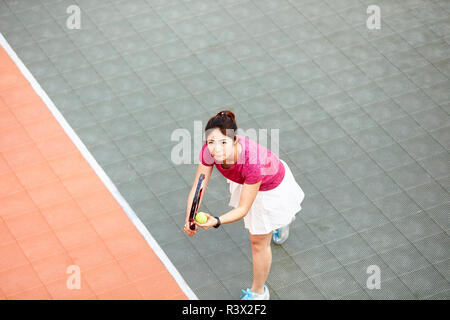 Junge asiatische Frau tennis player bereit zu dienen Stockfoto