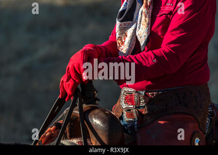 USA, Kalifornien, Clough, V6-Ranch in der Nähe von cowgirl Hände in roten Handschuhe auf dem Knauf des Sattels (MR) Stockfoto