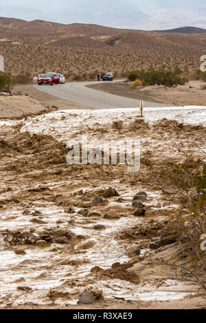 Autos sind hinter einer Flutwelle, die die Straße zu Ubehebe Crater im Death Valley National Park gewaschen hat sich durchgesetzt Stockfoto
