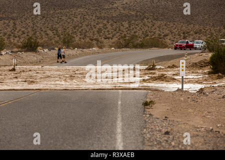 Touristen und Autos sind hinter einer Flutwelle, die die Straße zu Ubehebe Crater im Death Valley National Park gewaschen hat sich durchgesetzt Stockfoto