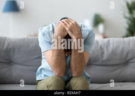 Deprimiert Mann auf der Couch sitzen, Leiden, Probleme Stockfoto