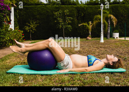 Schwangere Anheben einer Fitness Ball Stockfoto