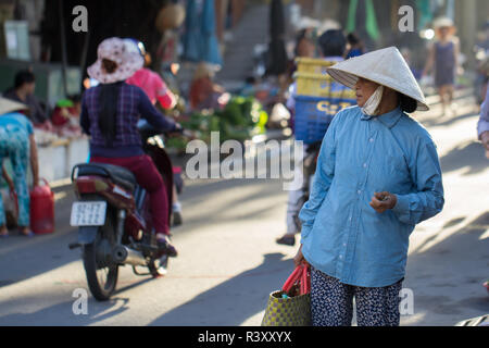 Vietnamesin in konischer Hut auf der Straße, Hoi An, Vietnam. Stockfoto