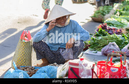 Vietnamesin in konischer Hut shopping frische Lebensmittel, Hoi An, Vietnam. Stockfoto
