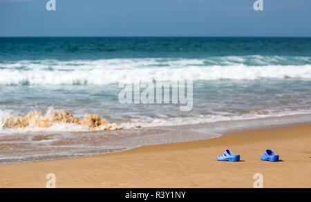 Frauen blaue Hausschuhe auf einem sandigen Strand Stockfoto