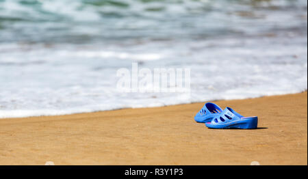 Frauen blaue Hausschuhe auf einem sandigen Strand Stockfoto