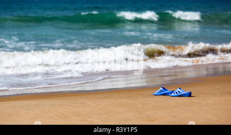 Frauen blaue Hausschuhe auf einem sandigen Strand Stockfoto