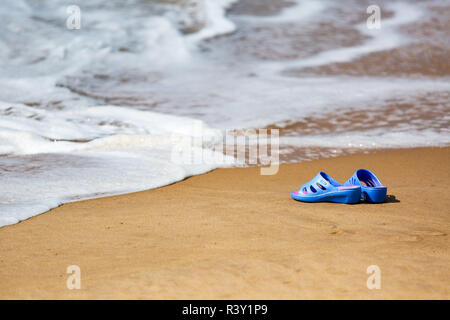 Frauen blaue Hausschuhe auf einem sandigen Strand Stockfoto