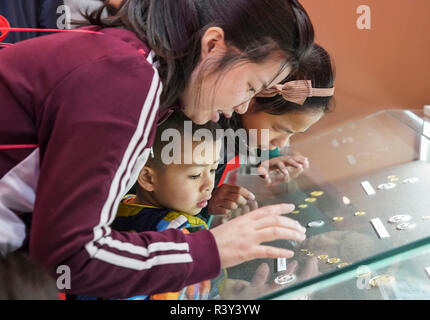 Peking, China. 24 Nov, 2018. Besucher Blick auf die gedenkmünzen in einer grossen Ausstellung zum 40-jährigen Jubiläum von Chinas Reform und Öffnung zu gedenken am Nationalmuseum in Peking, der Hauptstadt von China, Nov. 24, 2018. Credit: Yin Schleifring/Xinhua/Alamy leben Nachrichten Stockfoto