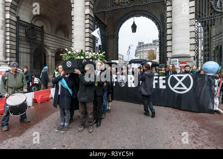 London, Großbritannien. 24. November 2018. Die cffin und Banner an der Vorderseite des Aussterbens Rebellion Trauerzug verwandelt sich in die Mall unter Admiralty Arch auf dem Weg zum Buckingham Palace. Peter Marshall / alamy Leben Nachrichten Stockfoto