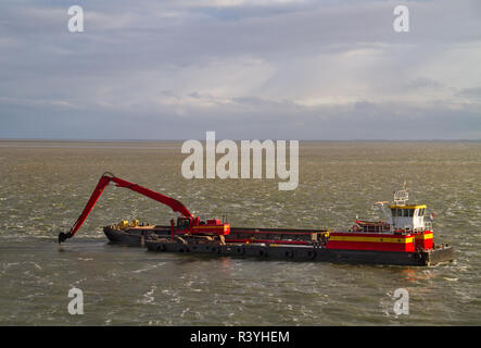 Red Baggerarbeiten Schiff arbeiten am Meer, Entfernen von Ablagerungen in einer Wasserstraße Stockfoto