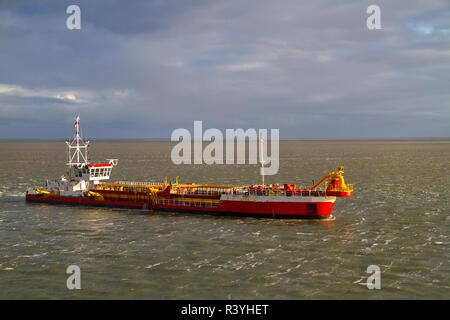 Red Baggerarbeiten Schiff arbeiten am Meer, Entfernen von Ablagerungen in einer Wasserstraße Stockfoto