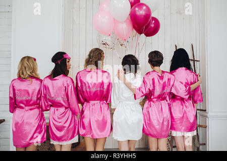 Brautjungfern in rosa Seide Roben mit dem Wort "BRAUTJUNGFER" auf Bac Stockfoto