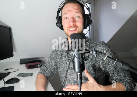 Junge männliche hinter Kondensator Mikrofon radio podcast Host voice recording Stockfoto