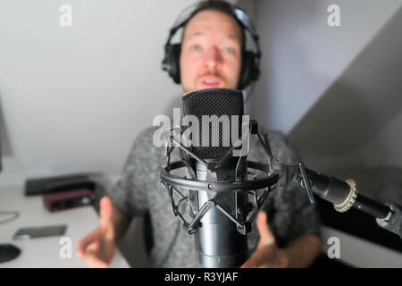 Junge männliche hinter Kondensator Mikrofon radio podcast Host voice recording Stockfoto