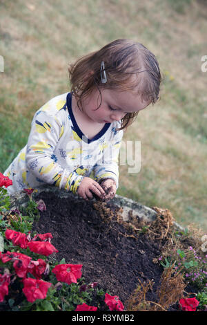 Kleinkind spielen in den Schmutz im Garten Stockfoto