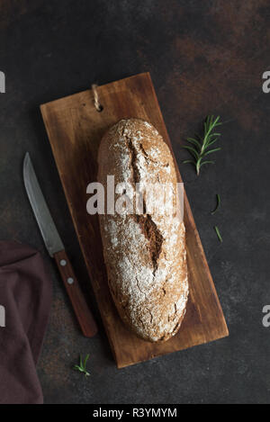Roggenbrot. Frische hausgemachte Brot auf dunklen Holzmöbeln im Landhausstil Hintergrund, Ansicht von oben, kopieren. Sourdough artisan Roggenbrot. Stockfoto