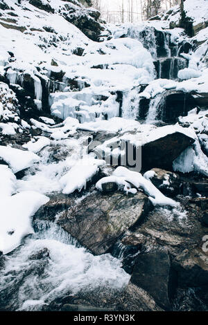 Schöne Shypit Waterfal und die Felsen mit Schnee bedeckt. Shypit Wasserfall auf Pylypets Fluss in den Karpaten, in der Nähe der Ortschaft Pylypet Stockfoto