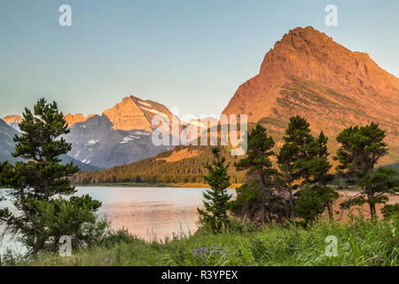 USA, Montana, Glacier National Park. Berg Reflexion über swiftcurrent Lake bei Sonnenaufgang. Stockfoto