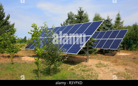 Zwei PhotovoltaikModule setzen im Garten gegen Bäume und blauer Himmel