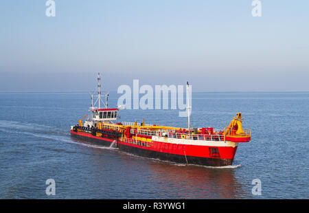 Red Baggerarbeiten Schiff arbeiten am Meer, Entfernen von Ablagerungen in einer Wasserstraße Stockfoto