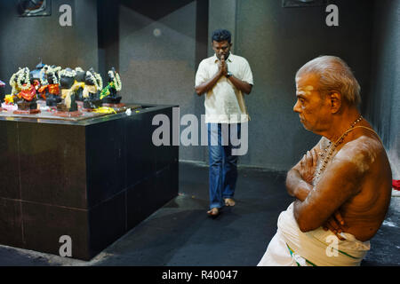 Der Priester steht vor der garbagraham beim Durchführen der Puja (Gebete) in Sri Mahamariamman Tempel, Kuala Lumpur, Malaysia Stockfoto