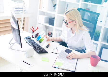 Ein junges Mädchen, die im Büro mit Computer und Dokumente. Stockfoto