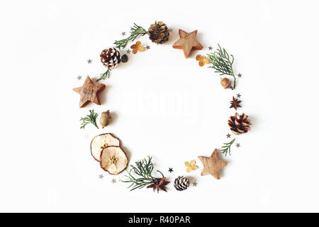 Weihnachten Kreis florale Komposition. Kranz der Zypresse Äste, Tannenzapfen, Anis, Konfetti Sterne, chemische Äpfel und Hortensie Blumen auf weißem Hintergrund. Winter Hochzeit Design. Flach, Ansicht von oben. Stockfoto