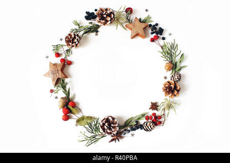 Weihnachten Kreis florale Komposition. Kranz von Cypress, Eukalyptus Äste, Tannenzapfen, Vogelbeeren, Anis, Konfetti Sterne und Meer holly Blumen auf weißem Hintergrund. Winter Hochzeit Design. Flach Stockfoto