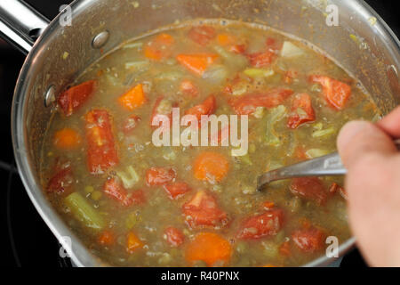 Rühren Linsensuppe in einer kleinen Pfanne Stockfoto