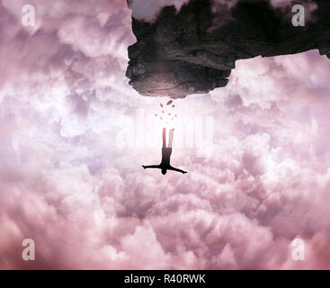 Eine Silhouette eines jungen Mannes springen von einem Gipfel des Berges, Klippe, auf der Himmelshintergrund. Freiheit und Risiko-Konzept. Stockfoto