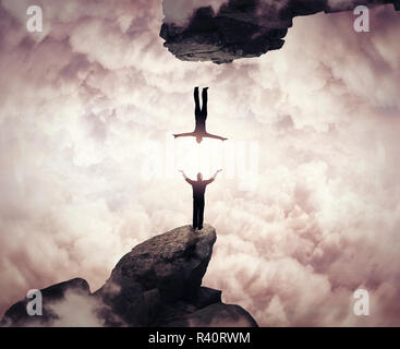 zwei Menschen-Silhouetten kommunizieren auf verschiedenen Gipfeln. In einer anderen Realität herunterfallen. Freiheit und Risiko-Konzept. Stockfoto