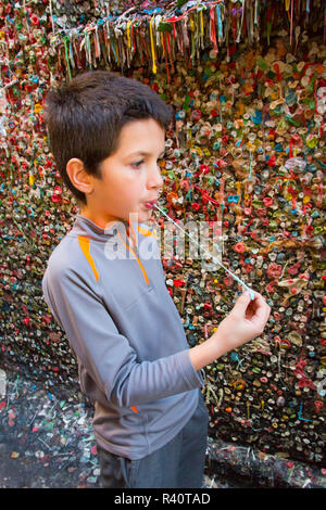 USA, Washington, Seattle. Ein 11-jähriger Junge Kaugummi neben dem berühmten Gummi Wand in Post-Gasse, Seattle, Washington. (MR) Stockfoto