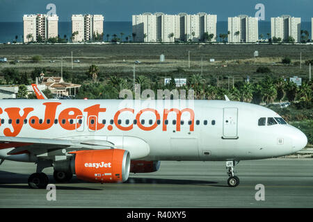 Flughafen Alicante, Airbus-Flugzeug, Easyjet-Flugzeug auf Asphalt und Gebäude am Meer Low-Cost Carrier LCC No-Schnills Budget Discount Airline Stockfoto