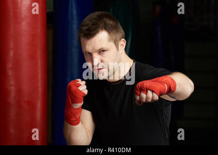 Portrait von Kickboxen Mann mit der Faust auf einen modernen Fitnessraum Hintergrund Stockfoto
