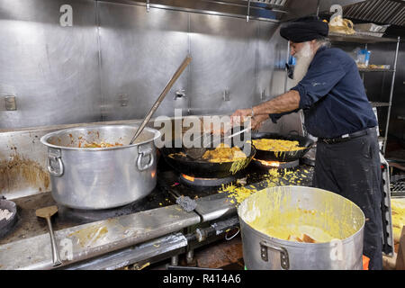 Ein Sikh Mann in einem langar - gemeinschaftsküche - bhature, Indische gebratenes Brot. An einem Tempel in Queens, New York City. Stockfoto