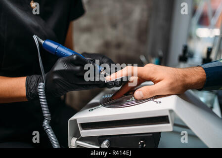 Weibliche Master in schwarz Handschuhe macht ein Mann Maniküre im Salon. Maniküre, Nail polieren Stockfoto