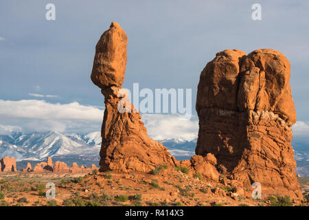 Utah. Nachmittag leuchtet auf Balanced Rock im Arches National Park mit den schneebedeckten La Sal Mountains im Hintergrund. Stockfoto