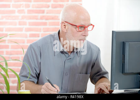 Senior Geschäftsmanns, der auf dem Computer Stockfoto