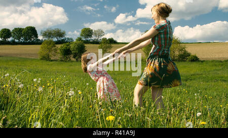 Mutter und Tochter zusammen tanzen im Wind auf einer frühlingswiese - Teil 2 Stockfoto