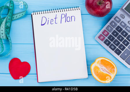 Kalorienarme Ernährung mit Früchten. Früchte, Maßband, Taschenrechner und Papier notebook. Diät plan Konzept. Stockfoto