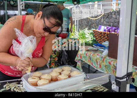 Captain Cook, Hawaii - Eine Frau bereitet Cupcakes im Pure Kona Grünen Markt. Stockfoto