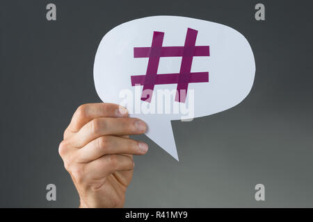 Hand mit Hashtag auf Sprechblase Stockfoto