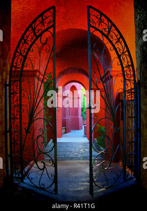 Ein reich verzierten schmiedeeisernen Tor führt zu einem farbenfrohen roten Korridor an der Squae Peak Hilton Resort Hotel in Phoenix, Arizona. Stockfoto