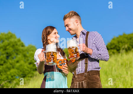 Deutsches Paar in Tracht trinkt Bier Stockfoto