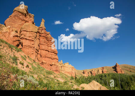 USA, Wyoming, Sublette County. Rote Burgen im Wyoming Berge stehen hoch gegen einen blauen Himmel. Stockfoto