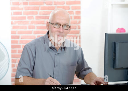 Senior Geschäftsmanns, der auf dem Computer Stockfoto