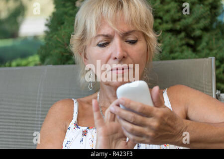 Ältere Frau lernt Ihr Smartphone einsetzen Stockfoto