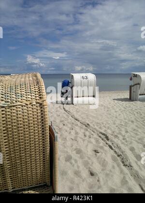 Am Strand - Fahrrad, Meer, Strand, Stuhl und Sand, ihre Spuren im Sand Stockfoto