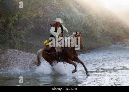 USA, Wyoming, Shell, das Versteck Ranch, Cowboy Reiten über den Fluss (MR, PR) Stockfoto